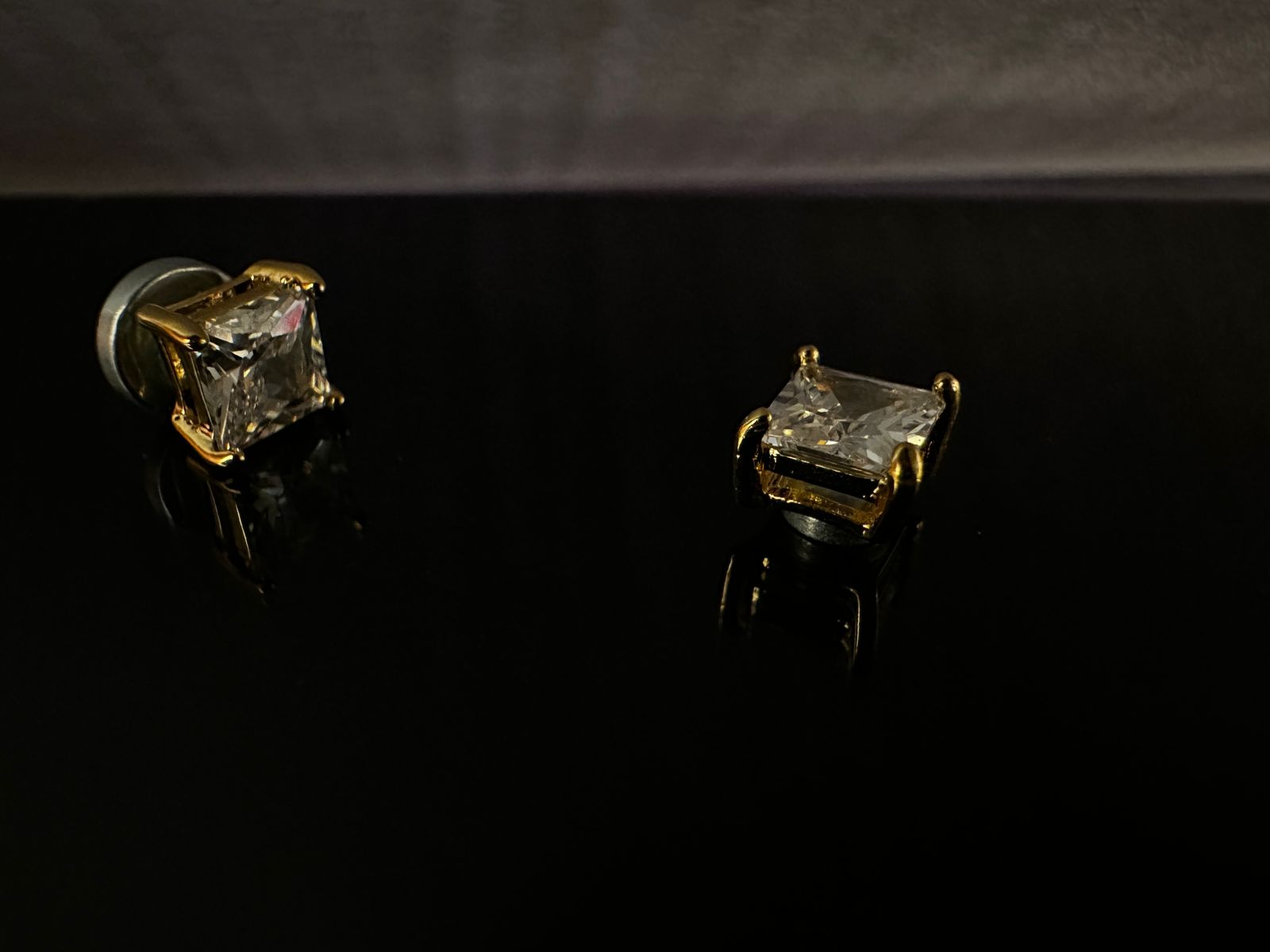 Pair of diamond stud earrings on a black background